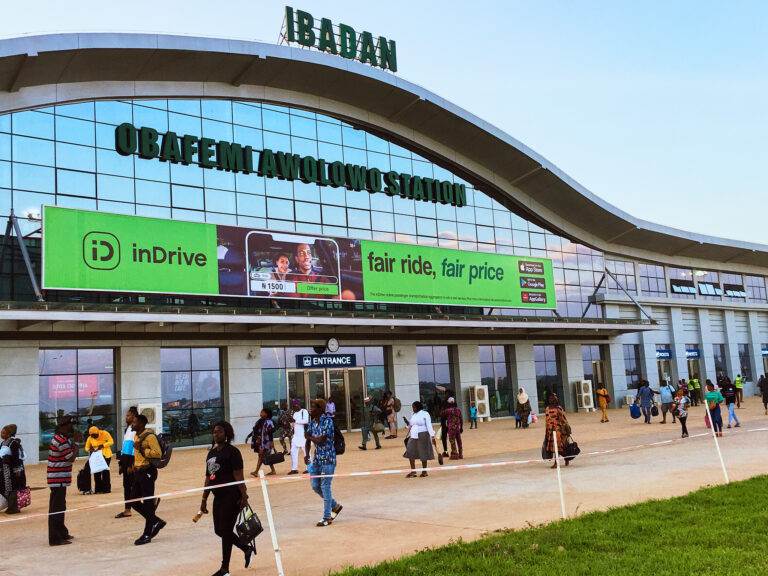 Arriving Passengers walking past the InDrive campaign in front of the Obafemi Awolowo Train station in Ibadan.